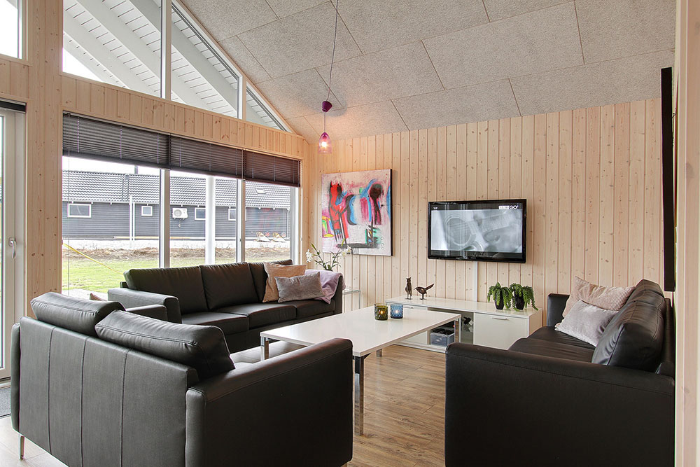 Den hyggelige sofagruppe med brændeovn indbyder til at hygge med en god bog eller et spil med familie og venner