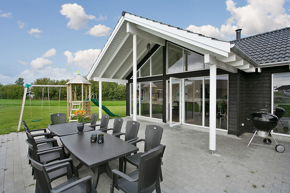 Der kan grilles og slappes af på husets store og delvist overdækkede terrasse. Til de mindste gæster er der lavet gynge og sandkasse i haven