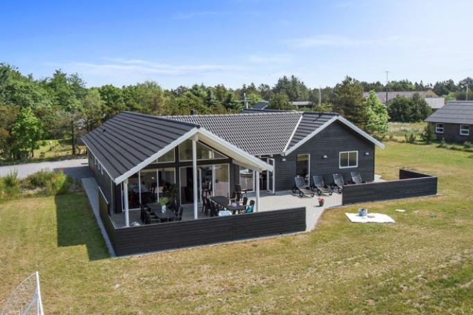 Dette eksklusive luksussommerhus er opført i et eftertragtet sommerhusområde tæt ved stranden og den charmerende ferieby Blåvand