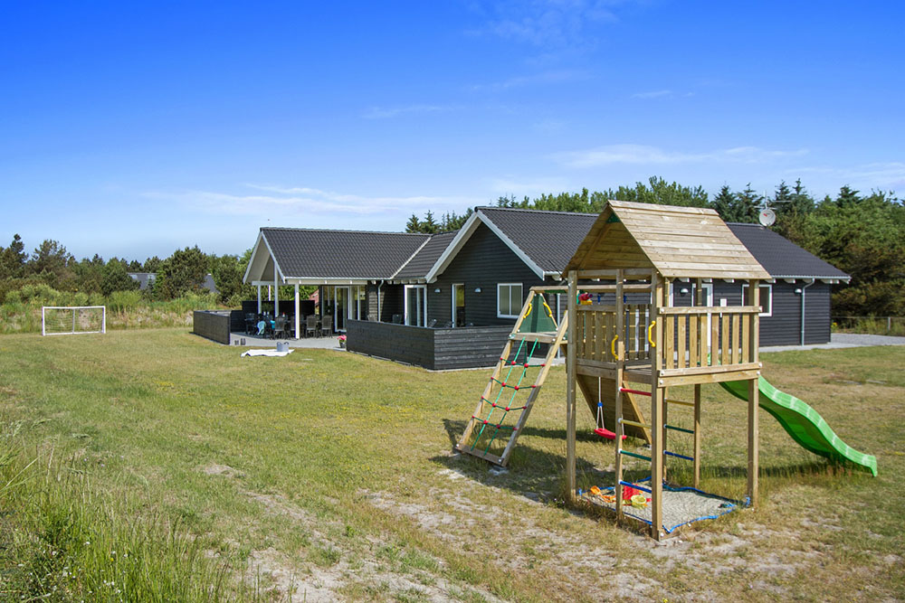 I det attraktive aktivitesrum i luksushus nr. 311 i Vestjylland  er der masser af udendørs aktiviteter, f.eks. legetårn og gynge