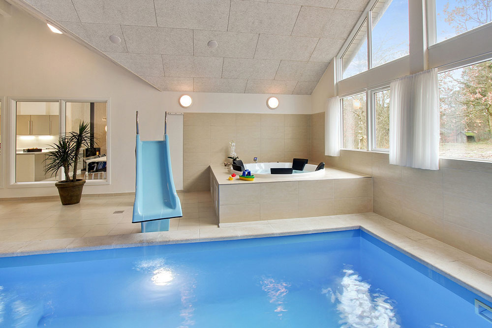 Både store og små vandhunde kan boltre sig i timevis i husets store pool med modstrømsanlæg og vandrutsjebane