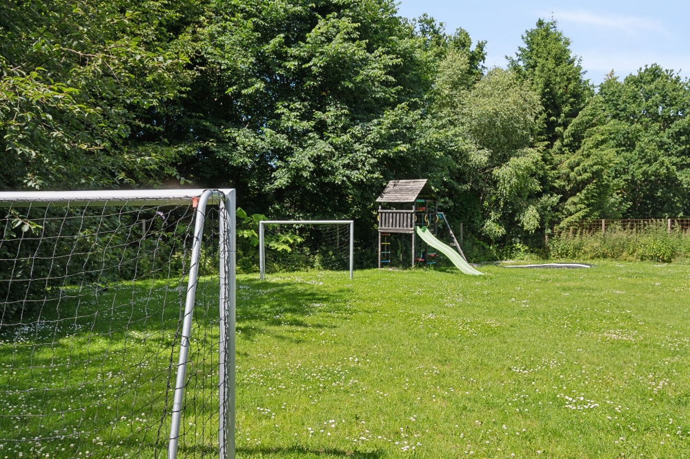 I det attraktive aktivitesrum i luksushus nr. 320 i Østjylland  er der masser af udendørs aktiviteter, f.eks. legetårn og gynge