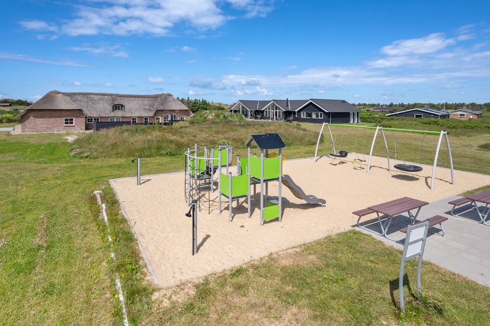 I det attraktive aktivitesrum i luksushus nr. 528 i Vestjylland  er der masser af udendørs aktiviteter, f.eks. legetårn og gynge