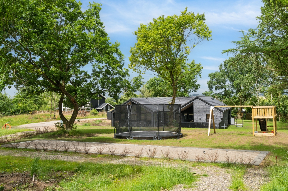 I det attraktive aktivitesrum i luksushus nr. 640 i Østjylland  er der masser af udendørs aktiviteter, f.eks. legetårn og gynge