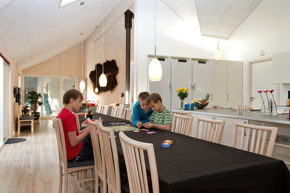 Det store opholdsrum er centralt placeret i huset og indrettet med rummeligt køkken, spisepladser og sofagrupper
