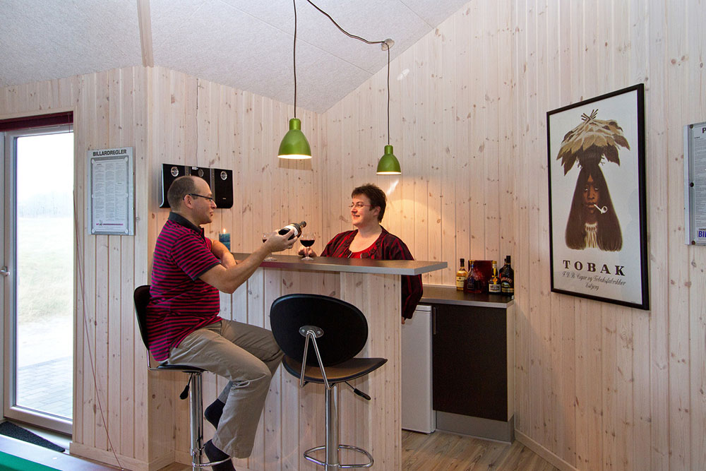 I husets aktivitetsrum er indrettet en hyggelig bar med køleskab, hvor der kan mikses drinks eller serveres en kold sodavand til de dystende