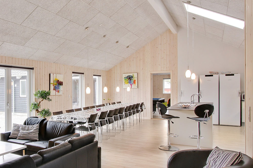Det centralplacerede køkkenalrum er indrettet med et rummeligt køkken, spisepladser og sofagruppe 
