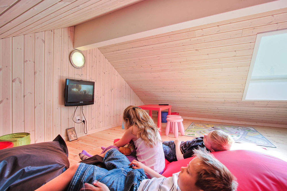Den ene hems er indrettet til børne-hjørne med børnemøbler, biltæppe og fladskærms-tv med DVD