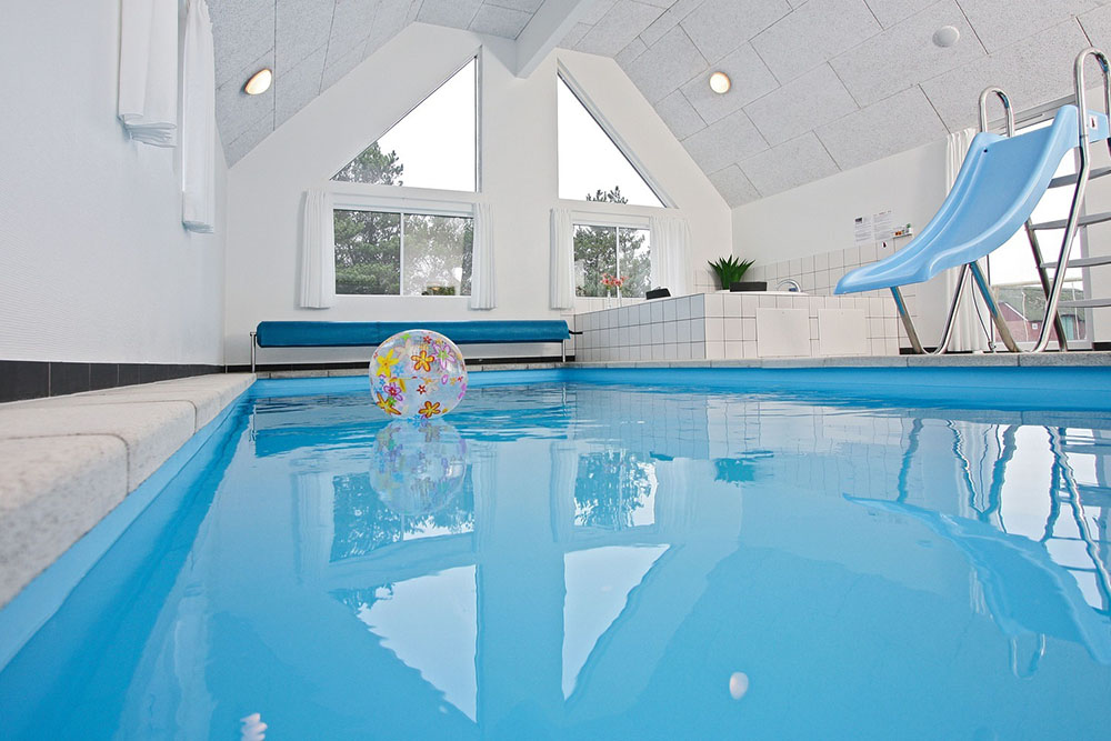 Både store og små vandhunde kan boltre sig i timevis i husets store pool med modstrømsanlæg og vandrutsjebane
