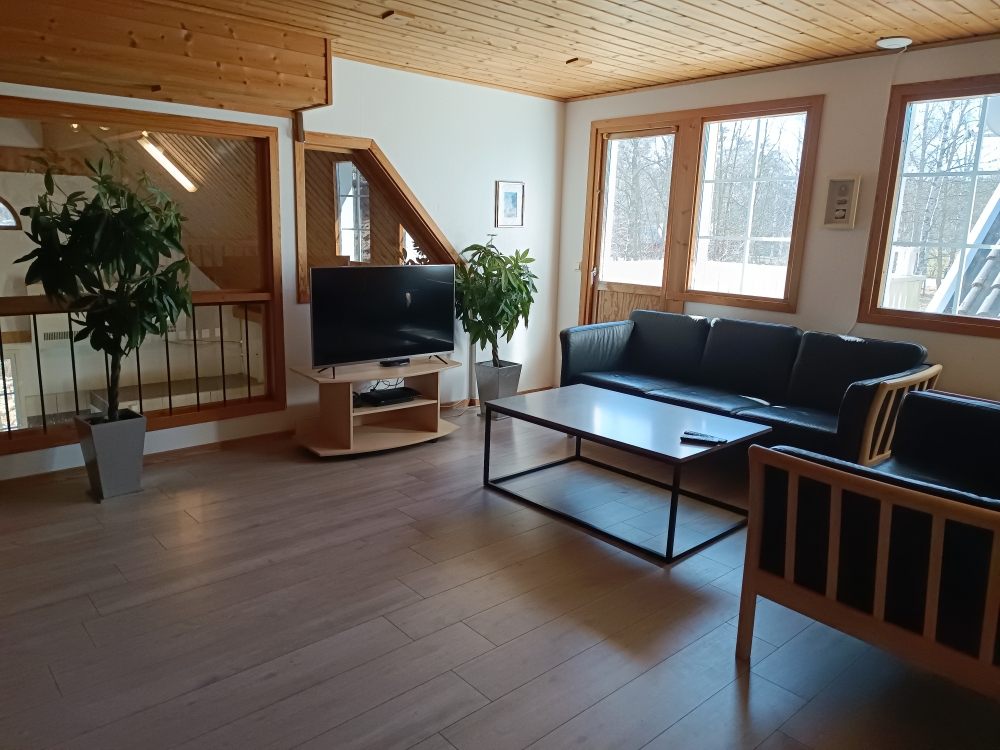 Stuen på 1. sal er indrettet med 2 sofagrupper, udgang til altanen og med kig til poolafdelingen