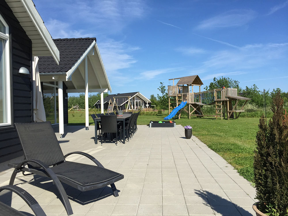 Den delvist overdækkede terrasse er perfekt til en sommerdag eller en grillaften, og til de mindste gæster er der sandkasse og gynge